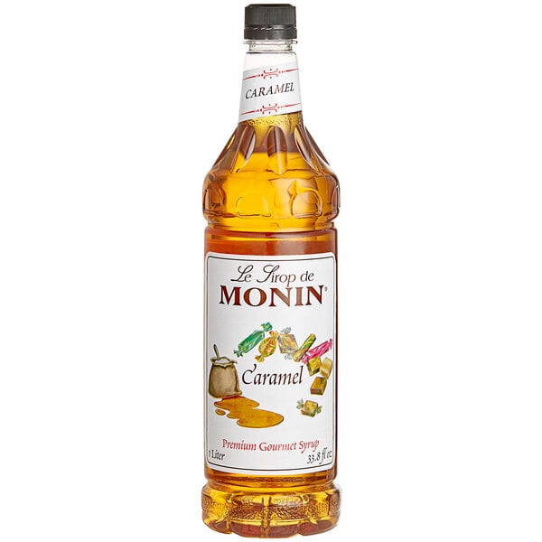A close up of a Monin Caramel Syrup bottle with a white label.