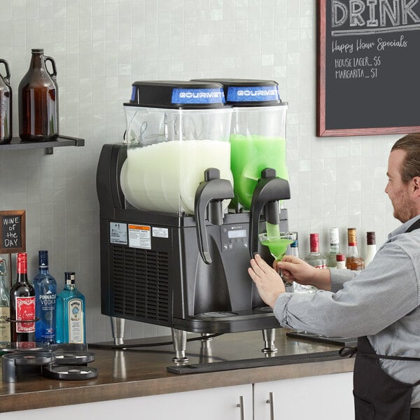 A man pouring green liquid into a Bunn liquid autofill slushy machine.