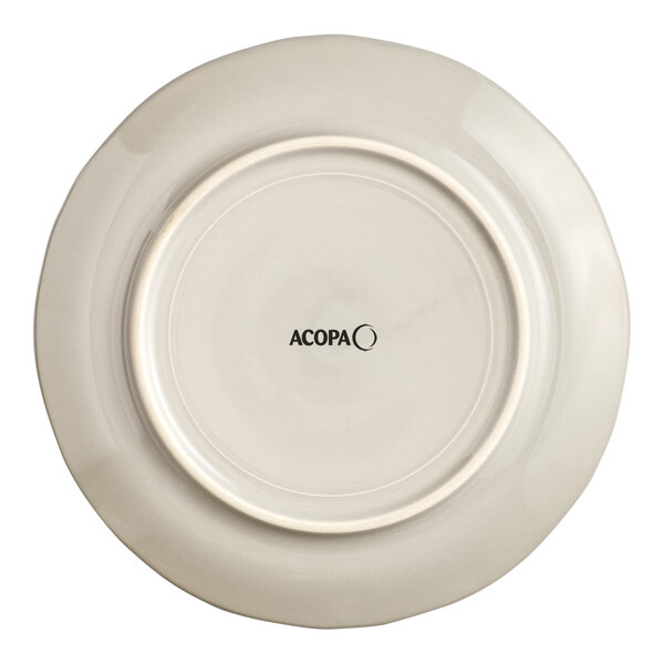 An Acopa Condesa warm gray porcelain plate with a scalloped rim and black text on it.