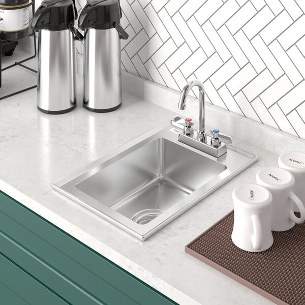 A Regency stainless steel drop-in sink in a kitchen counter with a white coffee mug.