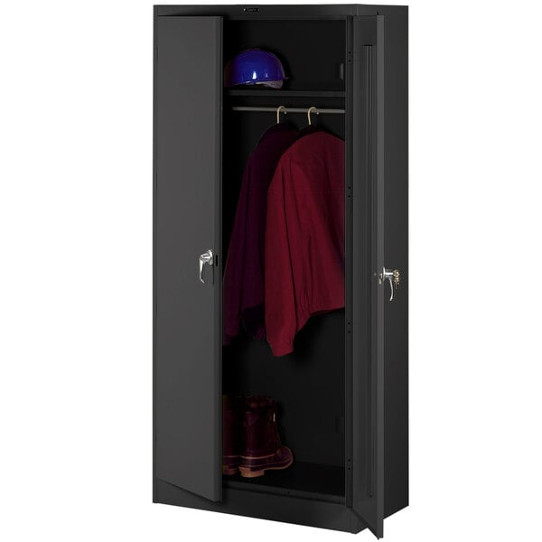 A black metal Tennsco Deluxe wardrobe cabinet with solid doors and a red shirt hanging on it.