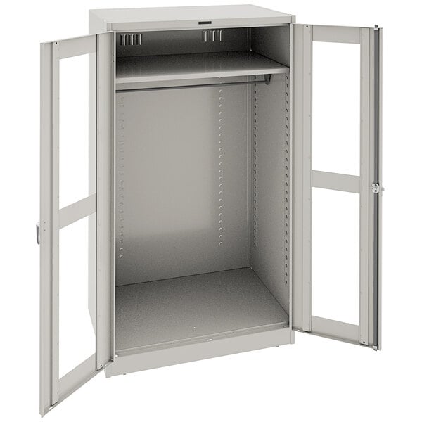 A light gray metal Tennsco wardrobe cabinet with open doors.