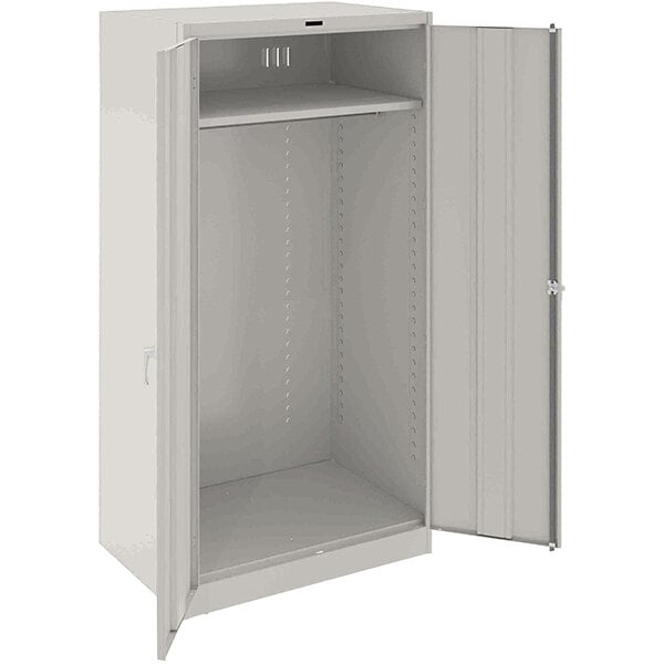 A light gray metal Tennsco wardrobe cabinet with open doors.