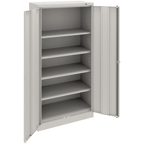 A light gray metal Tennsco storage cabinet with solid doors and shelves.