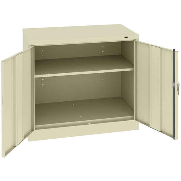 A beige Tennsco metal storage cabinet with open doors.