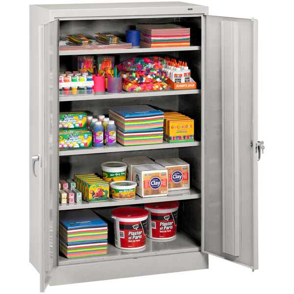 A Tennsco light gray metal storage cabinet with shelves full of items.