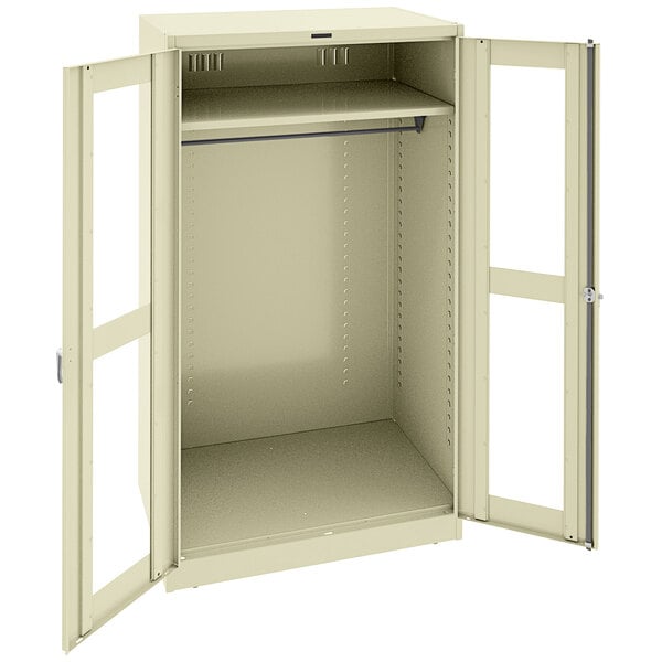 A white metal Tennsco wardrobe cabinet with open doors.