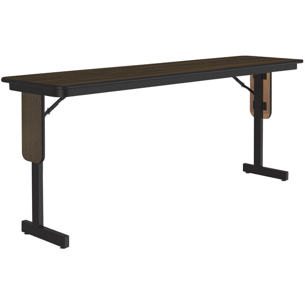 A Correll seminar table with walnut top and black panel legs.
