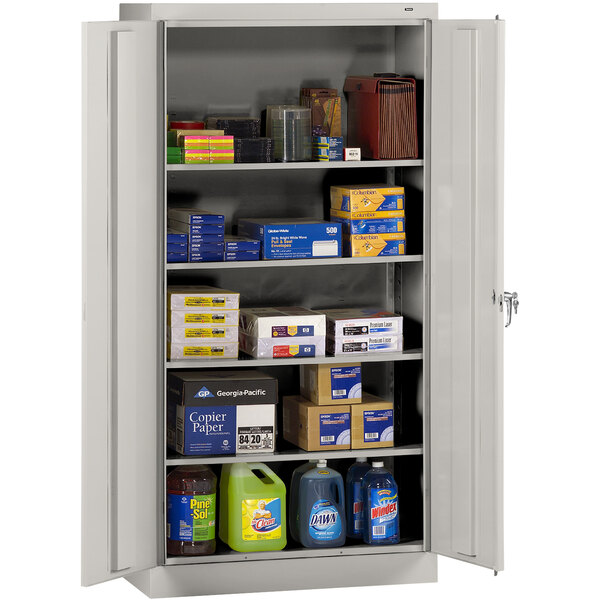 A Tennsco light gray metal storage cabinet with shelves full of items.