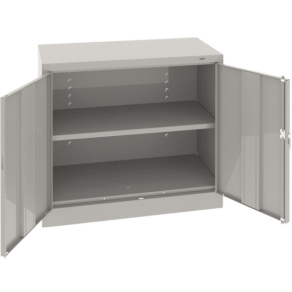 A light gray Tennsco metal storage cabinet with open doors.