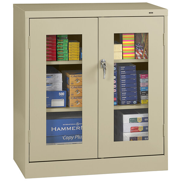 A Tennsco standard storage cabinet with C-Thru doors and shelves with books and files behind glass doors.