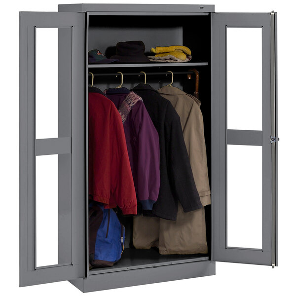 A dark gray metal Tennsco wardrobe cabinet with open C-thru doors holding coats and jackets.