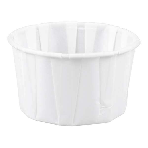 A small white paper souffle or portion cup.