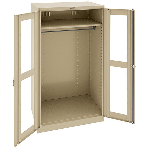 A tan metal Tennsco deluxe wardrobe cabinet with open doors.
