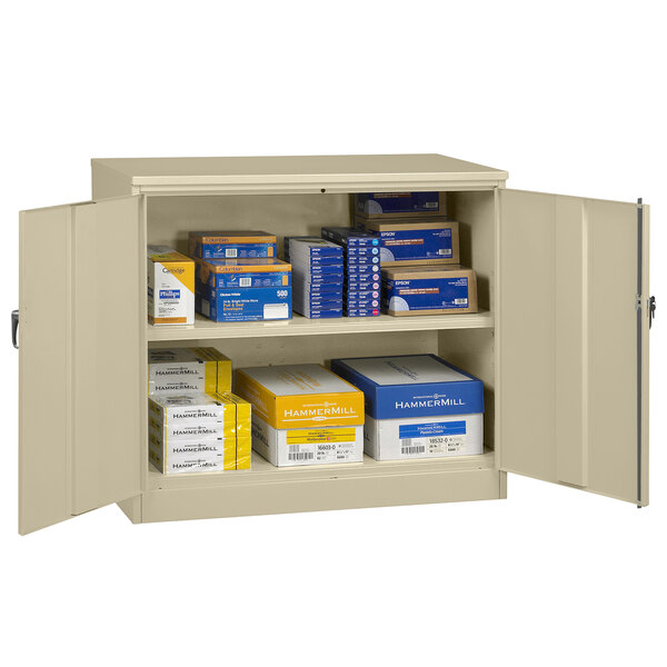 A Tennsco sand storage cabinet with solid doors open to reveal many white boxes.