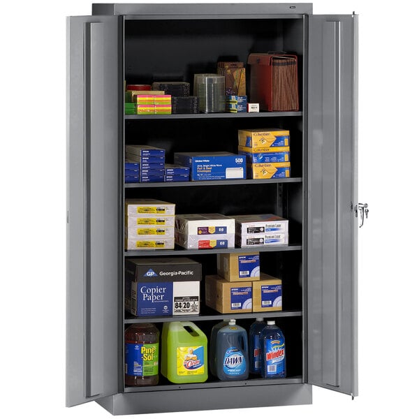 A dark gray Tennsco storage cabinet with shelves full of various items.