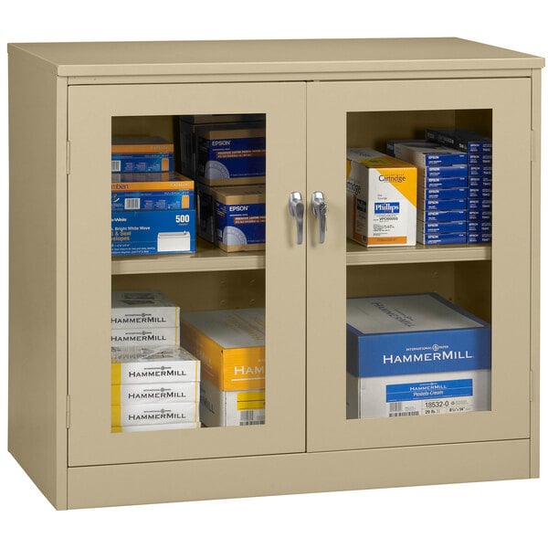 A Tennsco sand storage cabinet with C-Thru doors filled with blue and white boxes.