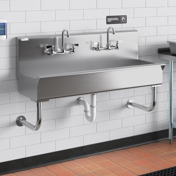 A stainless steel Regency wall-mounted utility sink with (2) faucets.