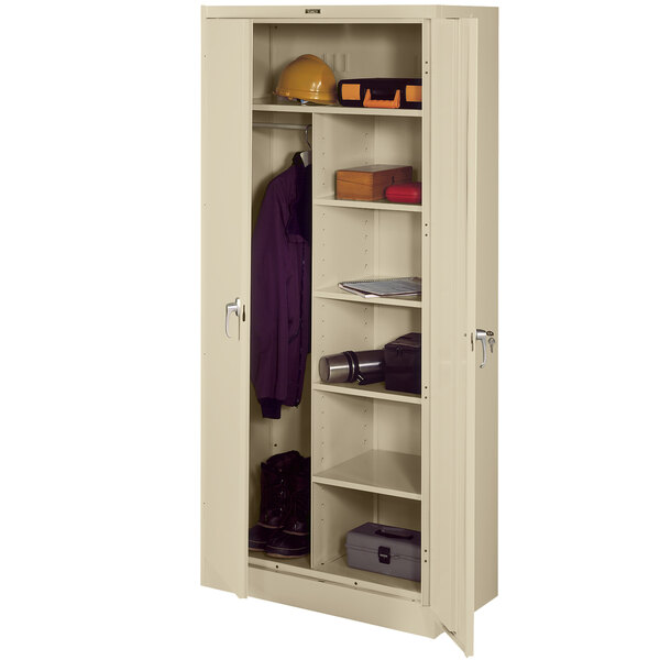 A white metal Tennsco combination cabinet with solid doors and shelves holding a coat and jacket.