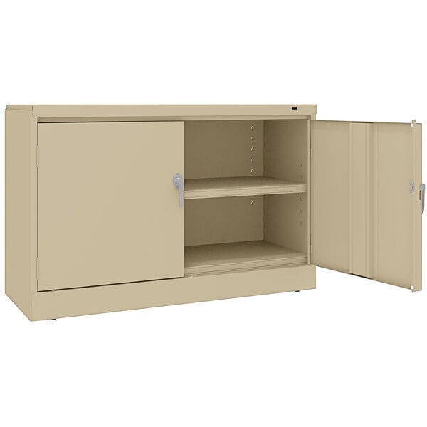 A tan Tennsco metal storage cabinet with solid doors.