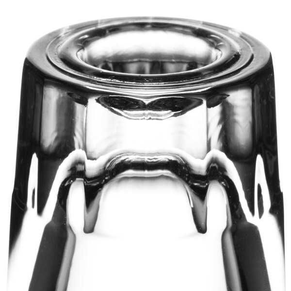 A close-up of a clear Libbey fluted shot glass with a white background.