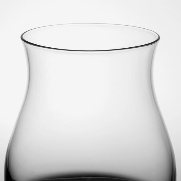 A close up of a Stolzle Canadian Whiskey Glass with black liquid inside.
