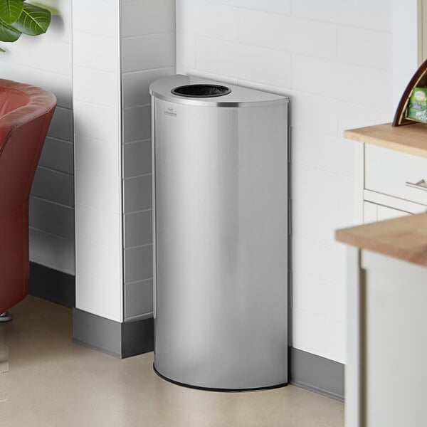 A Lancaster Table & Seating stainless steel half round decorative waste receptacle in a kitchen.