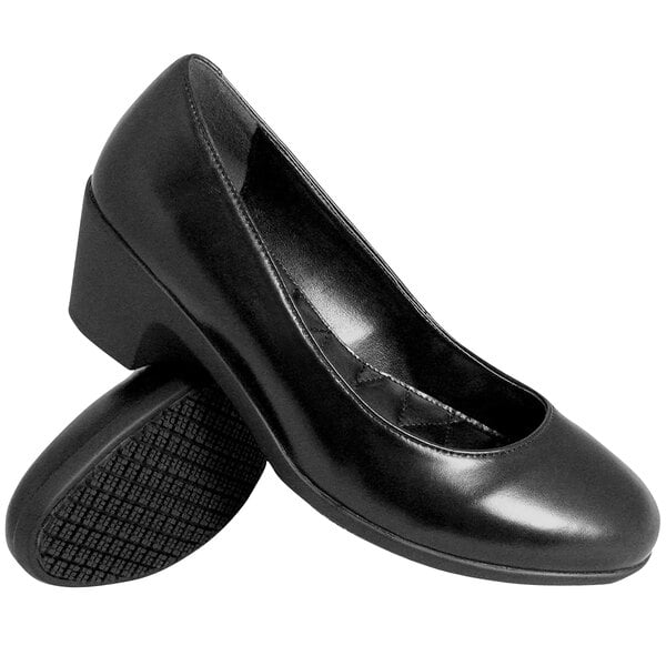 A pair of black, closed-toe, low wedge-heeled dress shoes with a smooth finish and textured non-slip soles.