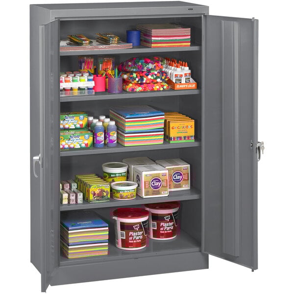 A grey metal Tennsco storage cabinet with shelves full of various items.