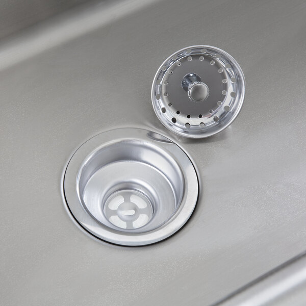 A close-up of a stainless steel Regency utility sink with a drain.