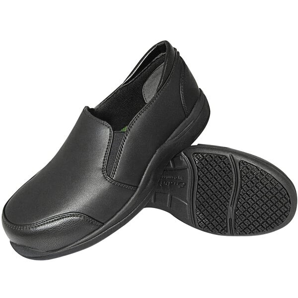 A pair of black slip-on shoes with a smooth upper and textured non-slip rubber soles, shown from a side and bottom view.