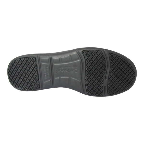 The image shows the black, textured sole of a shoe with a patterned tread for slip resistance.