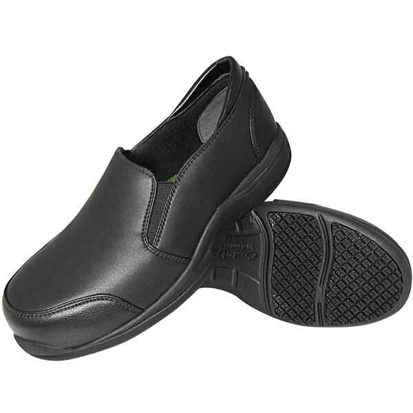 A pair of black slip-on shoes with a smooth upper and textured non-slip soles, shown from a side and bottom view.