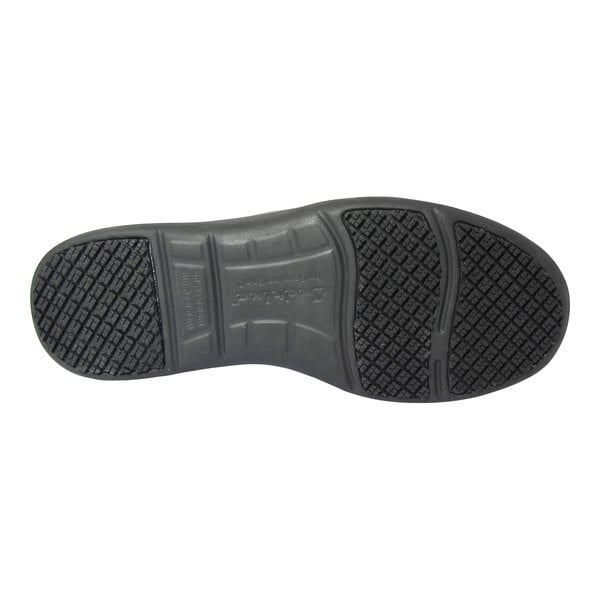 The image shows the black rubber sole of a shoe with a textured, non-slip tread pattern.
