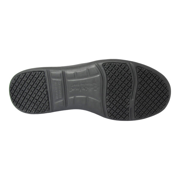 The image shows the black rubber sole of a shoe with a textured, non-slip tread pattern.