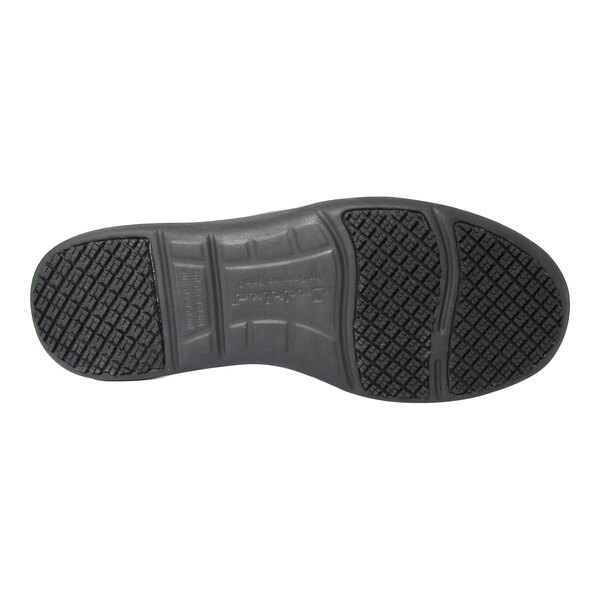 The image shows the black, textured sole of a shoe with a patterned tread for slip resistance.