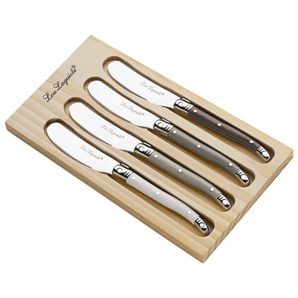 A group of Lou Laguiole Tradition butter spreader knives in a wooden box.