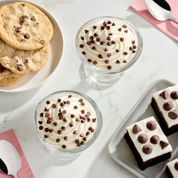 A display of desserts including chocolate chip cookies, brownies with chocolate chips, and parfaits topped with mini semi-sweet chocolate chips.