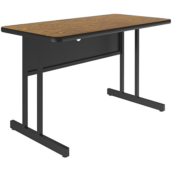 A medium oak Correll desk with black legs.