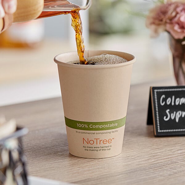 A person pouring coffee into a World Centric natural paper hot cup.