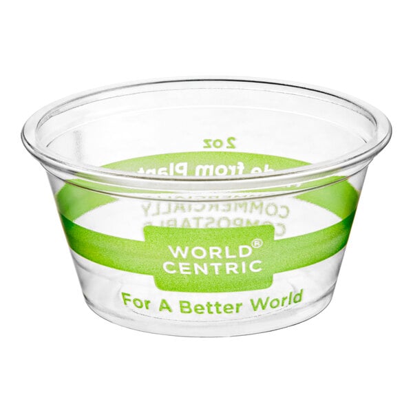 A clear plastic World Centric portion cup on a counter with a green World Centric label.