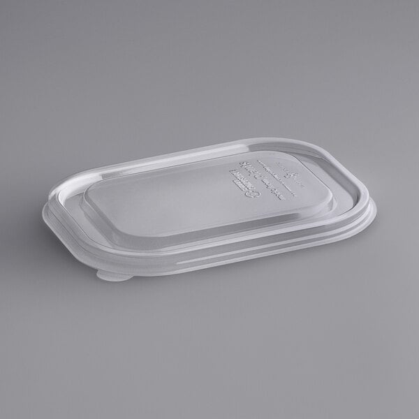 A World Centric clear plastic lid on a white surface.