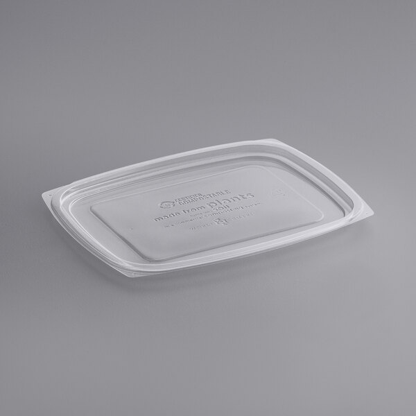 A clear World Centric plastic lid on a white surface.