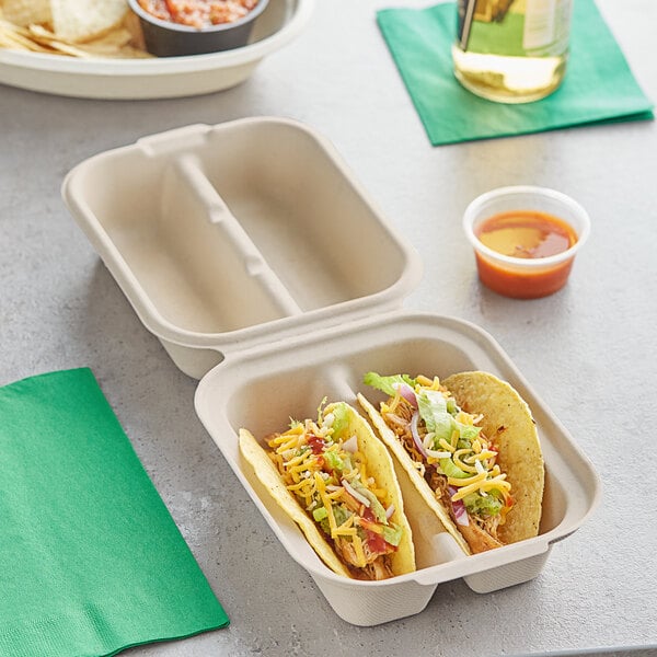 A white World Centric compostable fiber taco container with two compartments holding tacos.