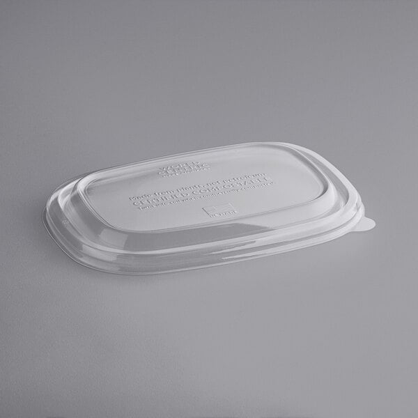 A clear World Centric compostable plastic dome lid on a plastic container.