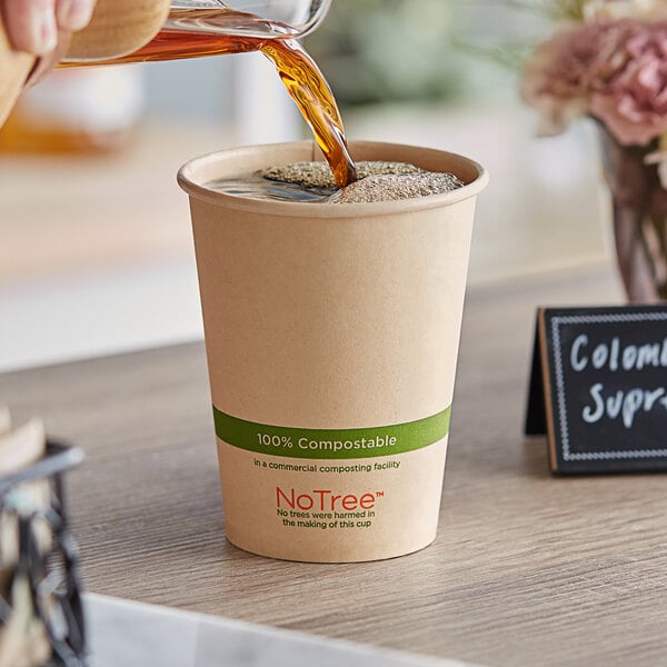 A person pouring coffee into a World Centric compostable paper hot cup.