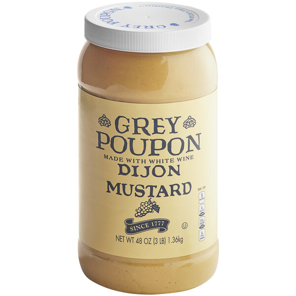 A jar of Grey Poupon Dijon Mustard on a white background.