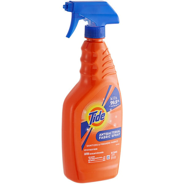 A close-up of a Tide Antibacterial Fabric Spray bottle with a blue handle.