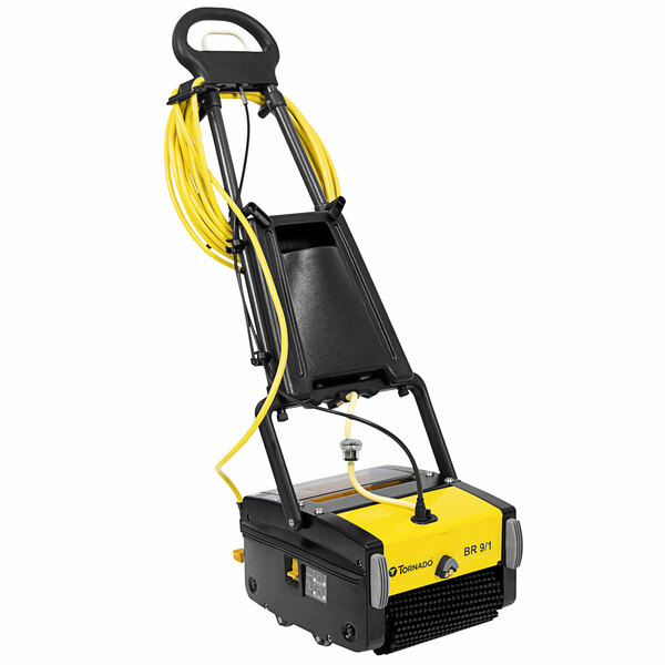 A yellow and black Tornado walk behind cylindrical floor scrubber with yellow tubes and a hose.