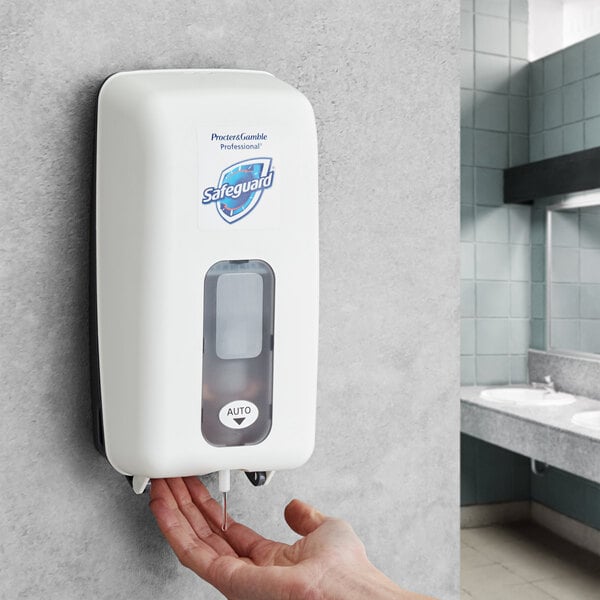 A hand using a Safeguard touchless hand sanitizer dispenser.